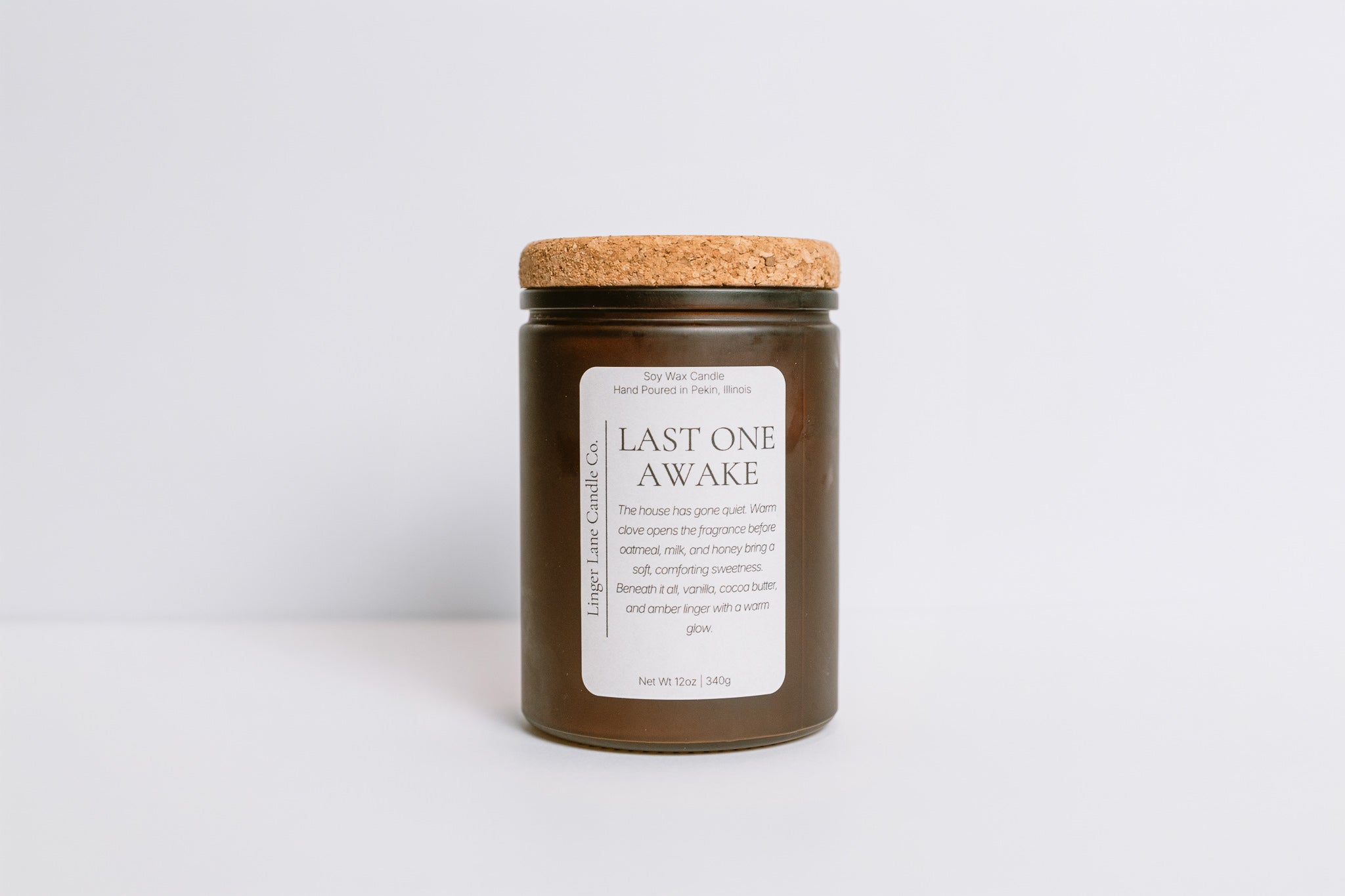Home fragrance soy Candle in a frosted brown glass jar with cork lid and 'Last One Awake' label on a white background