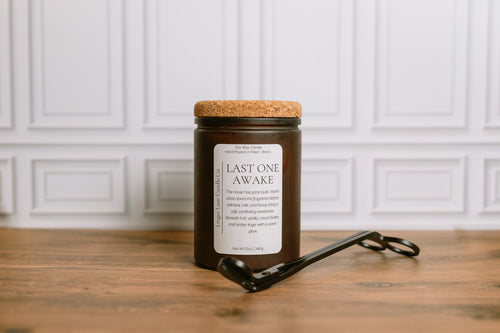 Frosted Brown candle jar with cork lid and label on a wooden surface