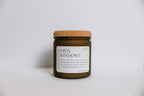 Scented soy Candle in a frosted amber jar labeled 'Open Windows' with a cork lid on a light gray background