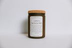Scented soy candle in a jar labeled 'Open Windows' with a cork lid on a light gray background