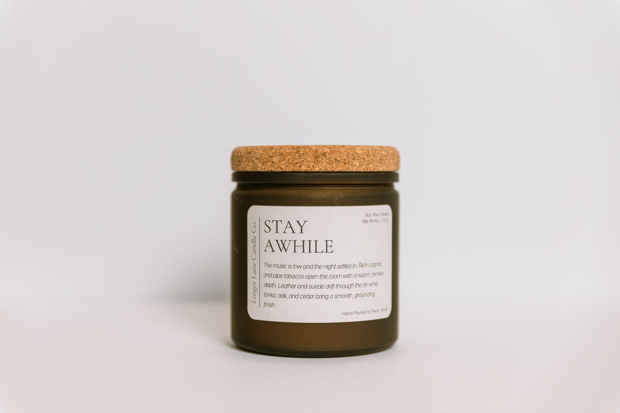 Hand poured, soy Candle with a cork lid and label on a light gray background